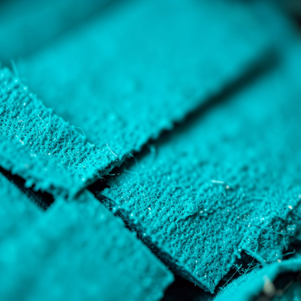A soft, atmospheric close-up of smooth pale teal and seafoam silk fabric, gently folded, lit with cool morning light, evoking a calm and meditative mood.
